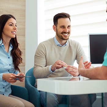 Young couple talking to dentist about sleep apnea treatment