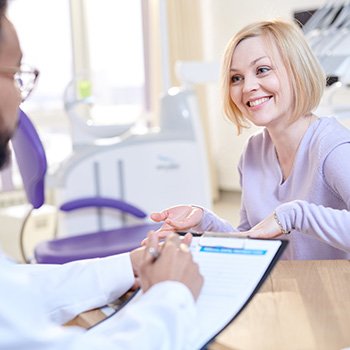 Woman talking to dentist about sleep apnea treatment 