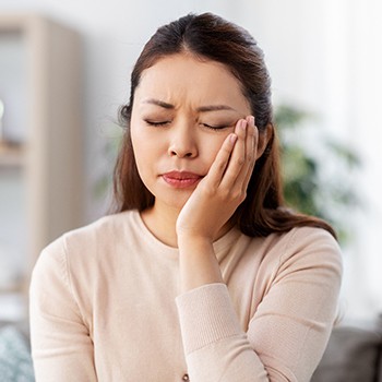 Woman with toothache in need of emergency dentist in Dyer